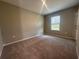 Comfortable bedroom with a large window offering natural light and plush carpeting at 3950 Alba Dr, Indian Lake Estates, FL 33855