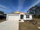 Charming single-story home with a manicured lawn, a two-car garage, and neutral tones at 3950 Alba Dr, Indian Lake Estates, FL 33855