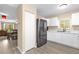 Well-lit kitchen with white cabinets, stainless fridge, and view of the adjacent dining area at 4102 Plantation Cove Dr # 201, Orlando, FL 32810