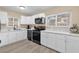 Bright kitchen featuring white cabinetry, marble countertops, and modern black appliances at 4102 Plantation Cove Dr # 201, Orlando, FL 32810