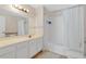 Well-lit bathroom featuring white cabinets, a large mirror, and a shower tub with a white curtain at 4600 Yellowgold W Rd # 102, Kissimmee, FL 34746