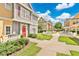 Inviting exterior showcasing well-maintained landscaping, colorful townhomes, and paved walkways under a bright sky at 4600 Yellowgold W Rd # 102, Kissimmee, FL 34746