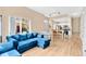 Open-concept living space with a comfy blue sectional, dining area, and modern kitchen featuring white cabinets at 4600 Yellowgold W Rd # 102, Kissimmee, FL 34746