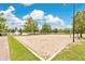 Community sand volleyball court surrounded by lush greenery and equipped with a well-maintained net at 4600 Yellowgold W Rd # 102, Kissimmee, FL 34746