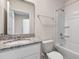 Well-lit bathroom with granite countertops, a mirror, and a combination tub and shower at 4602 Linda Dr, Lake Wales, FL 33859