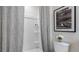 Compact bathroom has shower with gray patterned curtains, white tiles, and modern fixtures at 4616 Linda Dr, Lake Wales, FL 33859