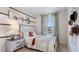 Cozy bedroom featuring a beautifully styled bed, decorative wall hangings, and a window with sheer curtains at 4616 Linda Dr, Lake Wales, FL 33859