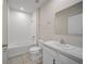 Well-lit bathroom with white tiled shower-tub combo, single sink vanity, and neutral tile flooring at 489 Panaro Ln, Haines City, FL 33844