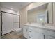 Bathroom featuring double sinks, white cabinets and a tiled shower with a glass door at 489 Panaro Ln, Haines City, FL 33844