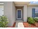 Covered entryway with stylish front door and neat landscaping, creating a warm welcome at 489 Panaro Ln, Haines City, FL 33844