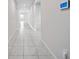 Long tiled hallway with recessed lighting, offering a clean and modern look with neutral walls at 489 Panaro Ln, Haines City, FL 33844