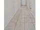 Long tiled hallway with doors at the end offering clean lines and access to multiple rooms at 489 Panaro Ln, Haines City, FL 33844