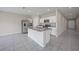 Open-concept kitchen with a central island, modern appliances, and bright white cabinets at 489 Panaro Ln, Haines City, FL 33844