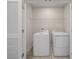Functional laundry room with washer, dryer, tile floors, and white doors, ready for chores at 489 Panaro Ln, Haines City, FL 33844