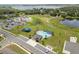 Aerial view of a community pool with a splashpad, playground, and parking lot at 489 Panaro Ln, Haines City, FL 33844