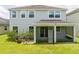 Backyard view of a house with a screened-in porch and a well-maintained lawn at 5161 Dove Tree St, Orlando, FL 32811
