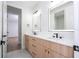 Double vanity bathroom with light wood cabinets, matte black faucets, and modern lighting at 5161 Dove Tree St, Orlando, FL 32811