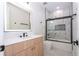 Modern bathroom featuring sleek vanity, illuminated mirror, and elegant marble-look tiled shower at 5161 Dove Tree St, Orlando, FL 32811