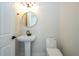 A stylish bathroom with a pedestal sink, round mirror, and modern fixtures, offering a clean design at 5161 Dove Tree St, Orlando, FL 32811