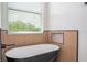 Relaxing black and white soaking tub by a window with natural light at 5161 Dove Tree St, Orlando, FL 32811