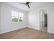 Sunlit bedroom with wood-look flooring, large window, and easy access to hallway and closet at 5161 Dove Tree St, Orlando, FL 32811