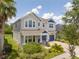 Stylish two-story home showcasing a manicured lawn and blue accents on the facade and two-car garage at 5161 Dove Tree St, Orlando, FL 32811