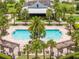 Aerial view of a sparkling community swimming pool with palm trees and seating areas at 5161 Dove Tree St, Orlando, FL 32811