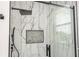 Shower stall with black hardware, marble-look tile, and built-in niche provides a luxurious experience at 5161 Dove Tree St, Orlando, FL 32811