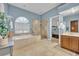 Bathroom with tub, tile shower, beige tile, blue walls and vanity at 5430 Baytowne Pl, Oviedo, FL 32765