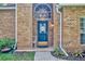 Inviting front entrance with a painted blue door, brick facade and colorful garden bed at 5430 Baytowne Pl, Oviedo, FL 32765
