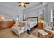 Bright main bedroom with tray ceiling, wood floors, and an ensuite bathroom at 5430 Baytowne Pl, Oviedo, FL 32765