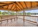 Interior view of a dock pavilion, featuring wood floors, wood beam ceiling and a bench overlooking a lake at 5430 Baytowne Pl, Oviedo, FL 32765