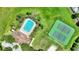 Aerial view of community pool, clubhouse, and tennis courts surrounded by lush green space at 546 Windsor Pl, Davenport, FL 33896
