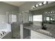 Bright and modern bathroom with double sink, shower, and marble tile at 546 Windsor Pl, Davenport, FL 33896