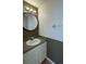 Stylish half bath with a modern vanity, updated mirror, and neutral color palette at 546 Windsor Pl, Davenport, FL 33896