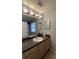 Bathroom vanity with a granite countertop, framed mirror, and decorative sconce lighting at 546 Windsor Pl, Davenport, FL 33896