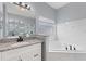 This is a modern bathroom with a tub, shower, vanity, and granite countertop at 546 Windsor Pl, Davenport, FL 33896
