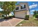 Well-maintained two-story house featuring a brick driveway and lush landscaping at 546 Windsor Pl, Davenport, FL 33896