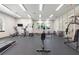 Well-equipped gym with treadmills, elliptical machines, weights, and plenty of natural light through large windows at 546 Windsor Pl, Davenport, FL 33896