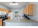Well-lit kitchen featuring wood cabinets and updated appliances near a sunny window at 546 Windsor Pl, Davenport, FL 33896