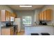 Galley-style kitchen has wooden cabinetry and stainless steel appliances at 546 Windsor Pl, Davenport, FL 33896