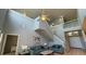 Bright, two-story living room featuring tile floors, ceiling fan and a staircase to the second floor at 546 Windsor Pl, Davenport, FL 33896