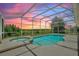 Screened-in pool with spa and sunset views at 546 Windsor Pl, Davenport, FL 33896