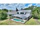 Aerial view of a backyard with a screened pool and lush green surroundings at 546 Windsor Pl, Davenport, FL 33896