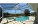 Inviting screened-in pool with spa and view of greenery at 546 Windsor Pl, Davenport, FL 33896