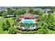 Aerial view of a sparkling community pool surrounded by lush landscaping and palm trees at 546 Windsor Pl, Davenport, FL 33896
