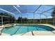 Inviting screened-in pool with spa and view of greenery at 546 Windsor Pl, Davenport, FL 33896