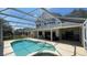 Expansive screened-in pool and patio area with ample seating and lush greenery at 546 Windsor Pl, Davenport, FL 33896