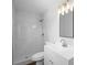 All-white bathroom features new shower with tile surround, modern vanity, new mirror, and updated lighting at 5815 Holmes Dr, Orlando, FL 32808