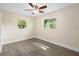 A bright bedroom with wood floors, ceiling fan and dual windows at 5815 Holmes Dr, Orlando, FL 32808